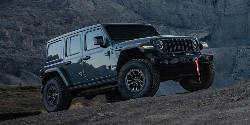 a 2026 Jeep Wrangler parked on a dark rocky stretch of land