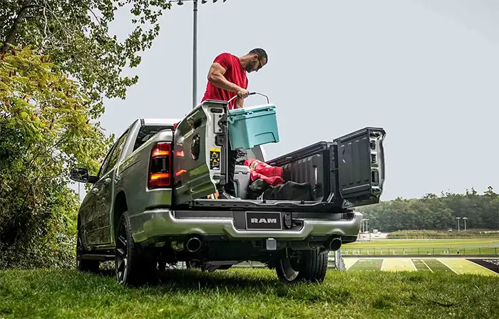 A man removing items from the back of a 2024 Ram 1500