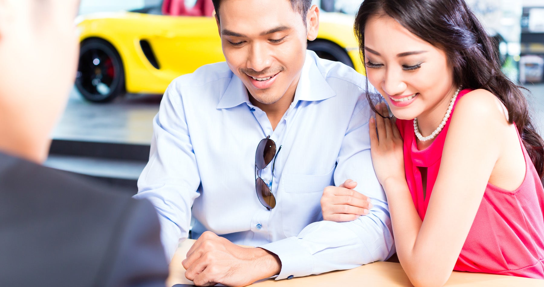 An employee going over paperwork with a man and woman