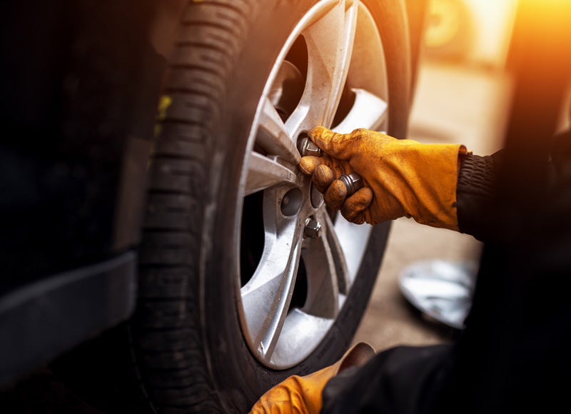 A technician attaching a tire to a vehicle